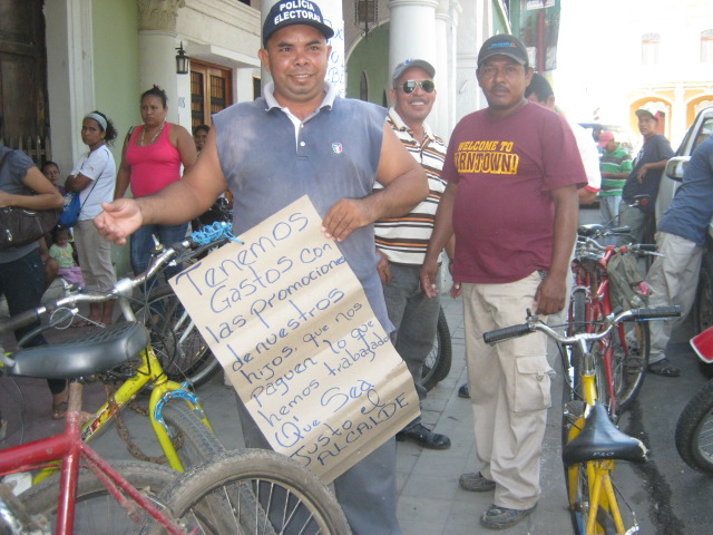 Los trabajadores, humildes barredores y vigilantes, esperan su paga